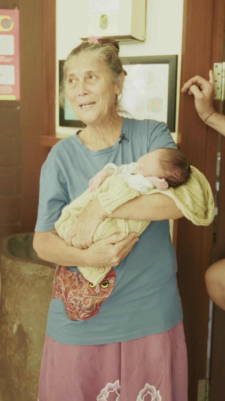 A birth worker holding a newborn at the clinic door