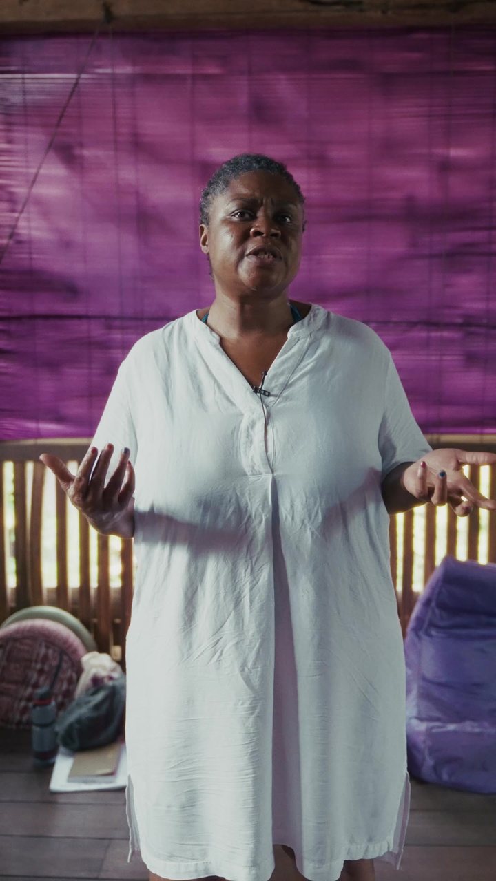 A midwife against a purple bamboo blind