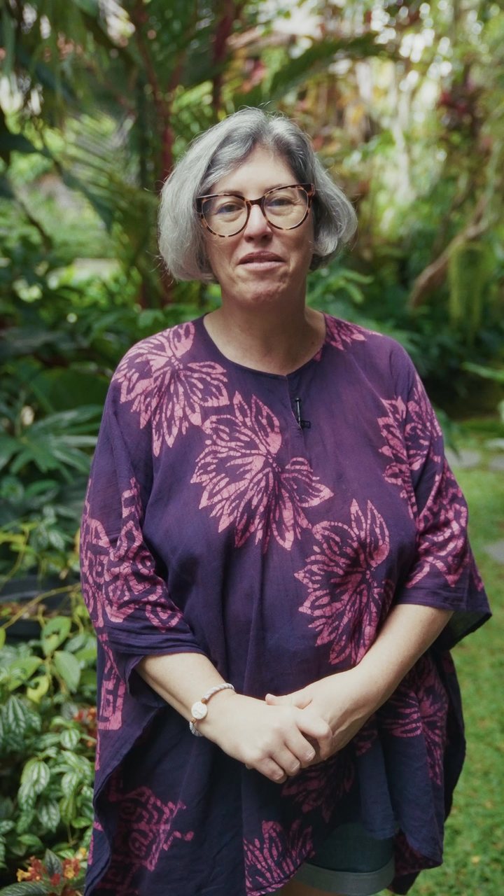 A woman in a purple dress among the plants