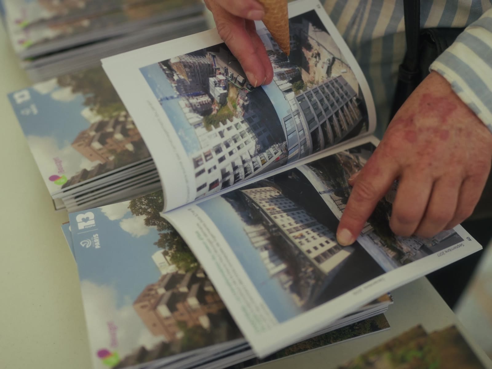 Hands turning the pages of a book of photographs of the estate