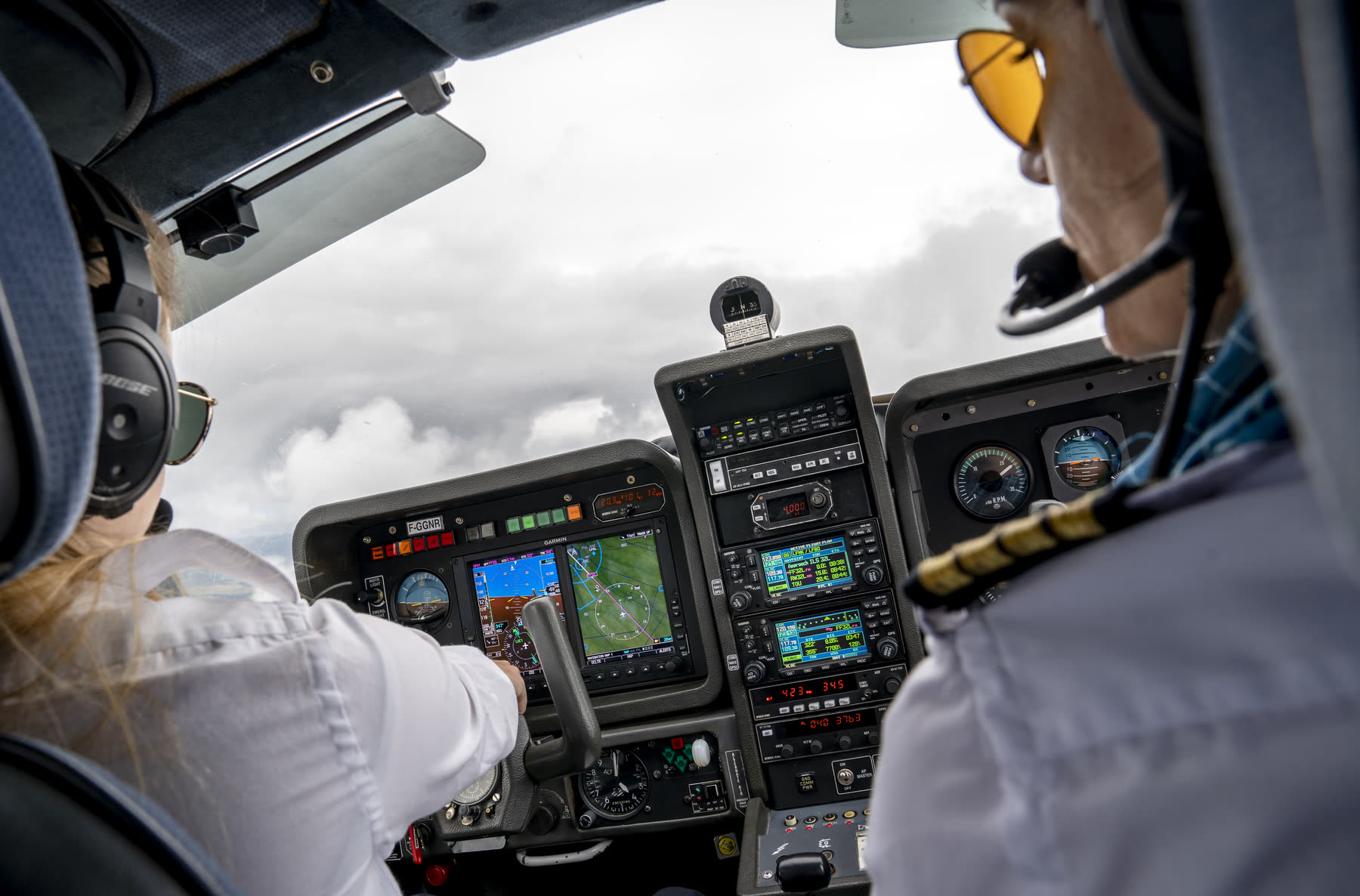 A student and her instructor in flight, at the glass cockpit