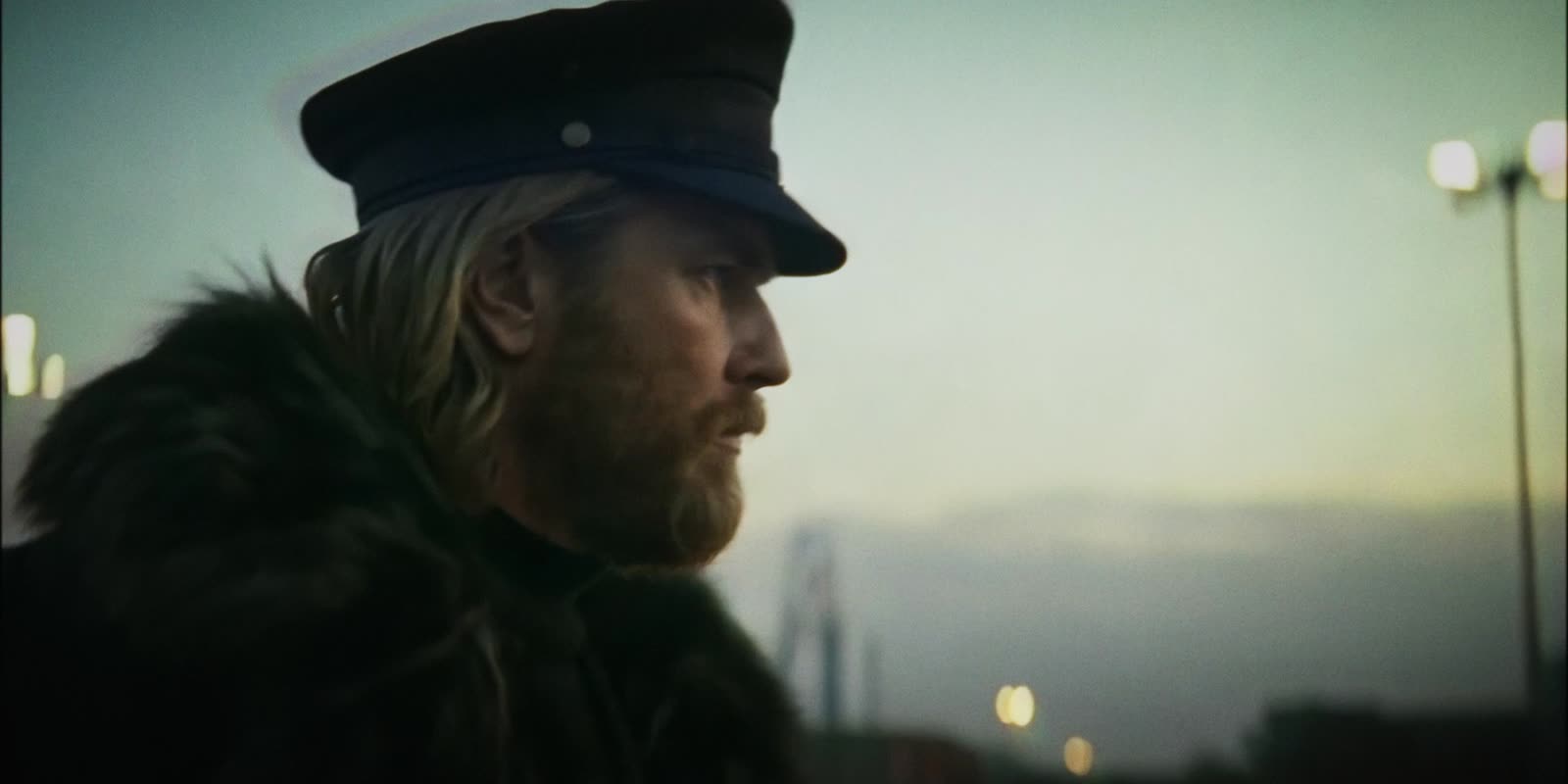 A bearded officer on a platform at dusk