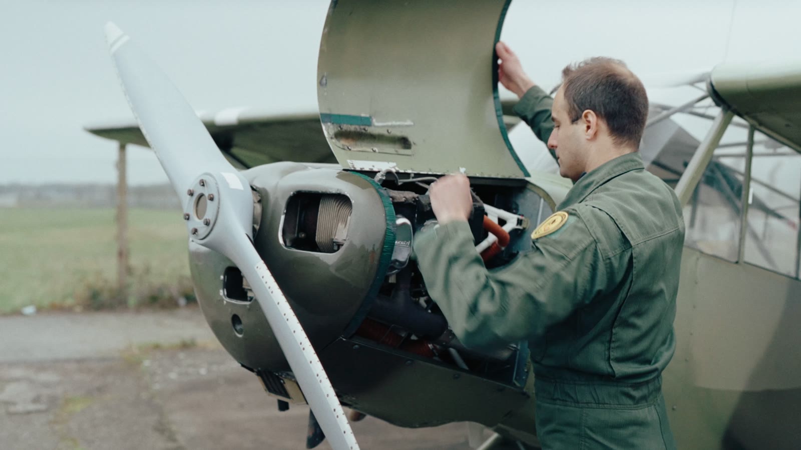 A pilot opening the engine cowling before the flight